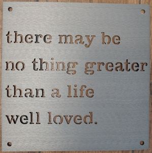 Metal sign with cutout wording.